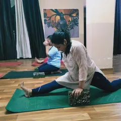 Here, a student deepens her stretch in a supported front split. This demonstrates how we work on increasing flexibility over time with safe and effective methods.