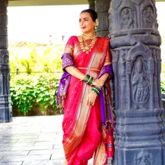 A full-length shot of a beautiful pink and purple Navari saree. The rich silk and traditional drape are perfect for a Maharashtrian wedding.