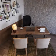 A close-up of the workspace, where a live-edge wooden desk is paired with modern chairs. The stone wall provides a beautiful, textured backdrop.