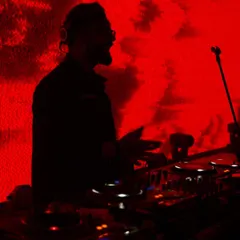 Late night sessions. A silhouette of me against the red lights of the DJ booth, completely absorbed in the music.