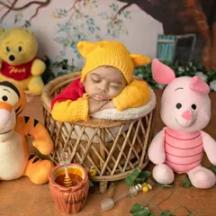 A tiny Winnie the Pooh curled up in a basket, dreaming of honey. I carefully pose newborns to ensure they are always comfortable and secure, allowing for these adorable themed shots.