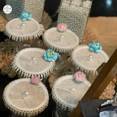 A collection of my embellished glass lids, showcasing different floral toppers in pink and blue. Each lid is edged with a fringe of pearls, adding a touch of vintage glamour.