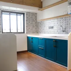 A full view of the PU finish kitchen, showcasing the seamless combination of teal blue lower cabinets and a clean white countertop against a patterned tile backsplash.