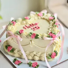 Heart-shaped but make it vintage. This dreamy 25th celebration cake features pastel rosettes, dainty pink bows, and intricate piping for a soft, romantic, and aesthetic vibe that’s made to be remembered.