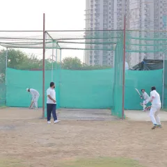 A batsman faces a bowler in our practice nets. This is where the grind happens, where techniques are corrected and perfected through countless hours of practice.