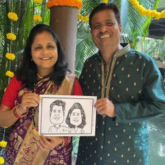 A happy couple with their caricature souvenir at a beautiful wedding in Thane. Our live sketching is a perfect way to entertain guests and give them a personal memento from your special day.