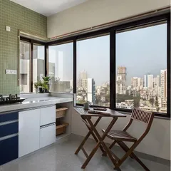 A compact kitchen designed to maximize space and views. We used light colors and a small, foldable breakfast table by the window to create a bright and airy spot for a morning cup of tea.