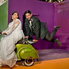 A fun and energetic pre-wedding photo with the couple on a classic scooter, showcasing a playful and unique theme.