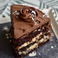 A close-up of Dee's German Chocolate Cake slice, a weekend special. The combination of dark chocolate cake, fudgy coconut filling, and caramelized walnuts is pure indulgence.