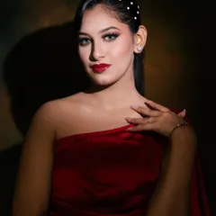 The dramatic lighting in this shot highlights the flawless skin and bold red lip, a classic combination that never goes out of style.