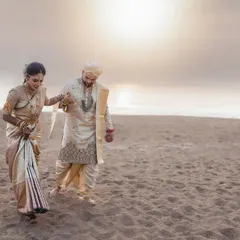 A couple walks along the beach at sunset during their destination wedding. The golden light and vast, empty sand create a feeling of romance and endless possibility.