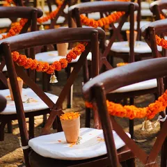 For a traditional wedding with a modern twist, I decorated the guest chairs with marigold garlands and a tiny brass bell. These small touches add to the overall theme and create a delightful visual consistency.