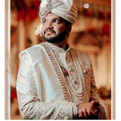 A classic portrait of the groom in his ivory sherwani, looking thoughtful and elegant.
