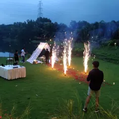 I create magical moments in any setting. This romantic anniversary picnic by the lake, complete with a beautiful tent, fairy lights, and cold pyro fireworks, shows how I can turn an outdoor space into a private, unforgettable experience.