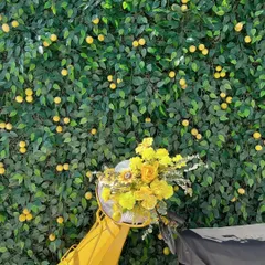 A bright yellow scooter, its basket overflowing with yellow flowers, parked in front of a lemon-tree wall. This playful prop served as a charming photo opportunity for guests.