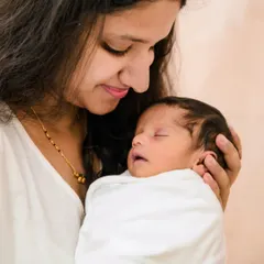 A close-up shot of a mother gazing lovingly at her sleeping newborn. These tender, quiet moments are the heart of my newborn photography sessions.