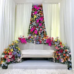 People hear 'Balloon World' and think we only do balloons. This vibrant, floor-to-ceiling floral installation proves otherwise. I used a rich variety of fresh, colorful flowers to create a breathtaking seating area for an engagement.