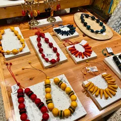 A customer photo showing our vibrant Channapatna jewelry displayed at our Indiranagar store. The collection includes a variety of necklaces in bold colors and unique shapes, all handcrafted from wood and finished with natural dyes.