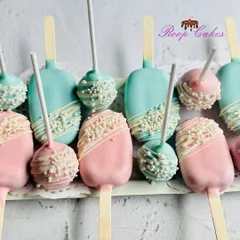 These modern cakesicles and cake pops are perfect for a gender reveal party. The treats are coated in pink and blue chocolate, finished with a white chocolate drizzle and pearl sprinkles for a touch of elegance.