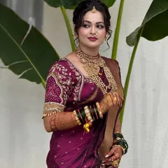 My beautiful bride Vaibhavi in a rich wine-colored saree with an embroidered blouse. Her makeup is kept soft and elegant to complement the royal feel of her attire.