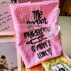 "The secret ingredient is mom's love." A custom-embroidered apron included in a thoughtful care package for a mother.