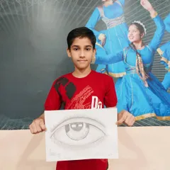 Learning to draw realistic features is a key skill. This student proudly displays his detailed pencil sketch of an eye, showcasing his understanding of shading and form.