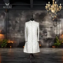 A modern take on regal attire, this off-white sherwani features a self-embossed geometric design. I've enhanced it with luxurious silver leather work and fine aari embroidery for a look that is contemporary yet timeless.