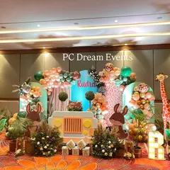 We brought the jungle to life for Rudra's first birthday with this large-scale safari theme decoration. The setup features a custom backdrop with a jeep cutout, friendly animal characters, and organic balloon garlands in a jungle-inspired color palette.