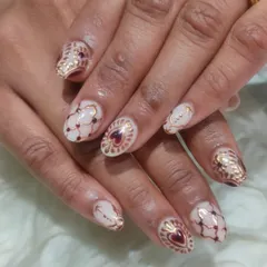An intricate design inspired by traditional patterns, featuring detailed gold line work and deep red heart-shaped gems.