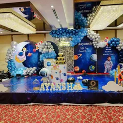 For the little explorer, I design out-of-this-world space themes. This setup features a floor-to-ceiling galaxy backdrop, custom astronaut and rocket cutouts, and a balloon arch in cosmic blues and silvers, making the birthday boy or girl the star of their own universe.