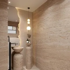 This powder room concept uses travertine stone to create a warm, earthy, and monolithic feel. The design features a sculptural pedestal sink and an organically shaped mirror, blending natural materials with modern forms.