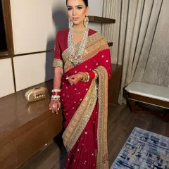 A classic, sleek low bun. This hairstyle is perfect for showcasing statement jewelry and the intricate details of a traditional outfit like this beautiful red saree.