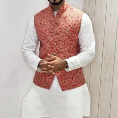 A close-up of a red and gold patterned Nehru jacket paired with a classic white kurta, a perfect combination for any celebration.