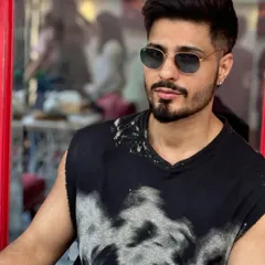 This is a great example of a modern fade haircut. The sides are kept very short and clean, blending seamlessly into a textured, styled top, complemented by a sharp beard line.