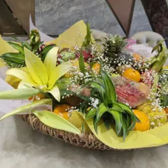 A side view of the fresh fruit arrangement, showing the height and dimension created with lilies and decorative greens. It’s more than a gift; it’s a centerpiece.