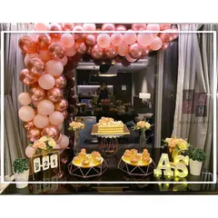 We love celebrating love, and this first-anniversary setup was all about modern romance. We designed a stunning rose gold and pink balloon arch over a dessert table, complete with custom initial marquee lights and geometric stands for a truly stylish and personalized event.