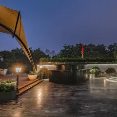 A wider view of the Vikaspuri terrace, showing the expansive stone flooring, integrated planters, and a tensile fabric canopy for shade.