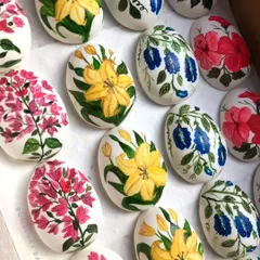 A collection of my hand-painted marzipan Easter eggs, featuring various floral designs like lilies, hibiscus, and bougainvillea.