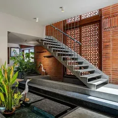 Here, I've integrated a shallow water body with stepping stones right into the home's interior design. The combination of water, stone, and plants next to the exposed brick wall creates a rich, sensory experience.
