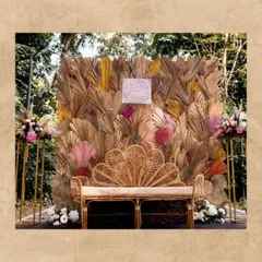 This cozy couple's seating nook is pure boho-chic. I used a peacock-style wicker chair set against a backdrop of dried palm leaves, creating a perfect, intimate spot for the bride and groom.
