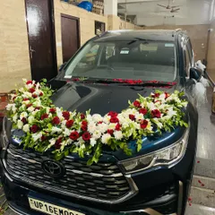 The fully decorated wedding car, ready for the groom to bring his bride home. The floral arrangement on the hood is lush and elegant.