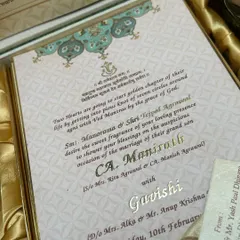 A look inside a luxury hamper box. The invitation itself is exquisitely detailed with gold foil text and traditional patterns, setting the tone for a grand celebration.