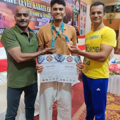 A senior student celebrates his success, earning medals in both kata and kumite categories at the state championship, showcasing his all-around skill.