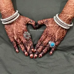 A heart pose to show off the lovely henna stain. Accessorized with rings and bangles, the dark mehendi really stands out.