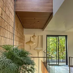 A detail from 'The Brick Affair', where the texture of the brick wall is complemented by the warmth of a wooden ceiling and sculptural pendant lights.