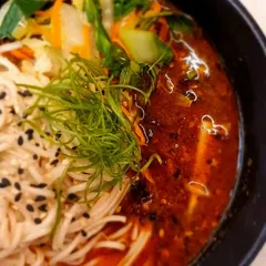 A close-up of a flavourful Asian noodle soup. We make our broths and curries from scratch, and our Khao Suey is one of the best in the city.