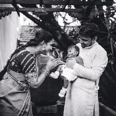 A beautiful black and white portrait of new parents adoring their baby. This style of photography emphasizes the raw emotion and connection in the early days of family life.