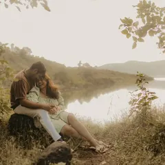 A serene and intimate portrait of a couple nestled by a calm lake. The vintage, rustic tones of this photo enhance the feeling of warmth and tranquility in this nature-filled pre-wedding shoot.
