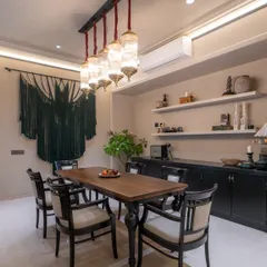 This versatile room serves as both a dining area and a home theatre. I designed a small pantry corner to display family heirlooms, while a custom 6-foot macrame wall hanging adds a modern craft element, creating a functional space filled with stories.