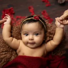 A newborn holding onto her parent's fingers. This classic shot is a powerful symbol of the connection and trust between you and your baby.